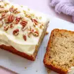 Hummingbird bread topped with cream cheese frosting and pecans
