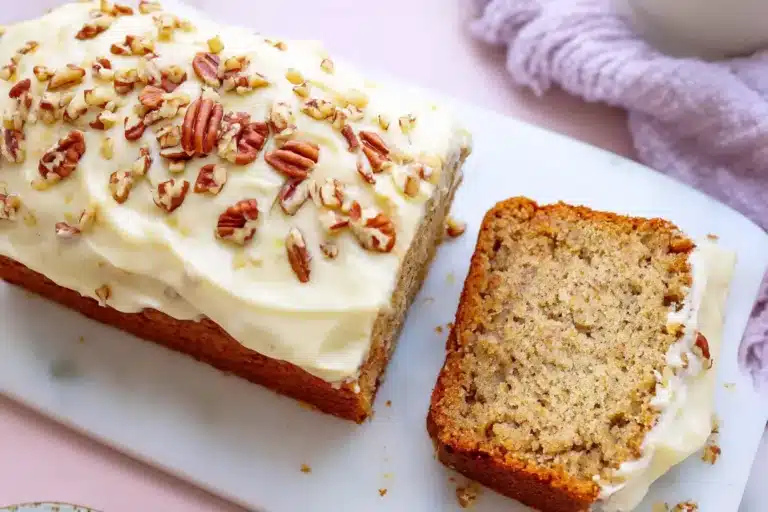 Hummingbird bread topped with cream cheese frosting and pecans